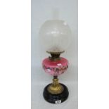 A Victorian table oil lamp with decorative pink glass reservoir, etched shade and chimney