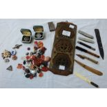 A tin containing various collectable items including agate samples, penknives, lapel badges,