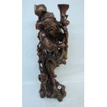 A 24" Oriental carved hardwood figure of a man carrying a sack, with a much smaller man at his feet