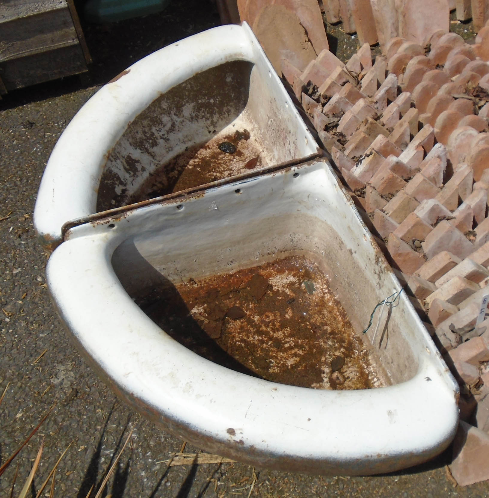 A pair of enamelled cast iron corner horse troughs