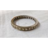 An unmarked white metal diamond encrusted eternity ring