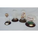 Four glass domed models, comprising two sailing ships, a biplane and a hot air balloon