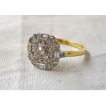 A marked 18ct. yellow metal ring with open set central diamond, four baguettes to compass points and