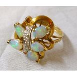 A marked 14K yellow metal ornate dress ring, set with five drop shaped opals and meandering row of