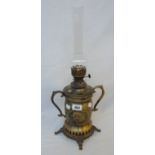 An Iranian brass table oil lamp with embossed crown and lion and sun decoration, with chimney