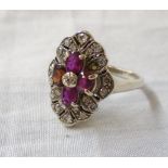 An 18ct. white gold Victorian style marquise panel ring, set with three rubies and one replacement