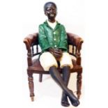 A 4' 1930's painted plaster figure of a seated black man