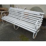 A 6' early 20th Century wrought iron framed garden bench with later white painted finish