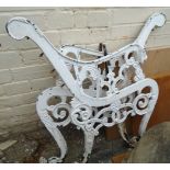 A pair of white painted cast iron bench ends