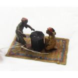 A cold painted bronze Arab group of two boys playing dice at a table