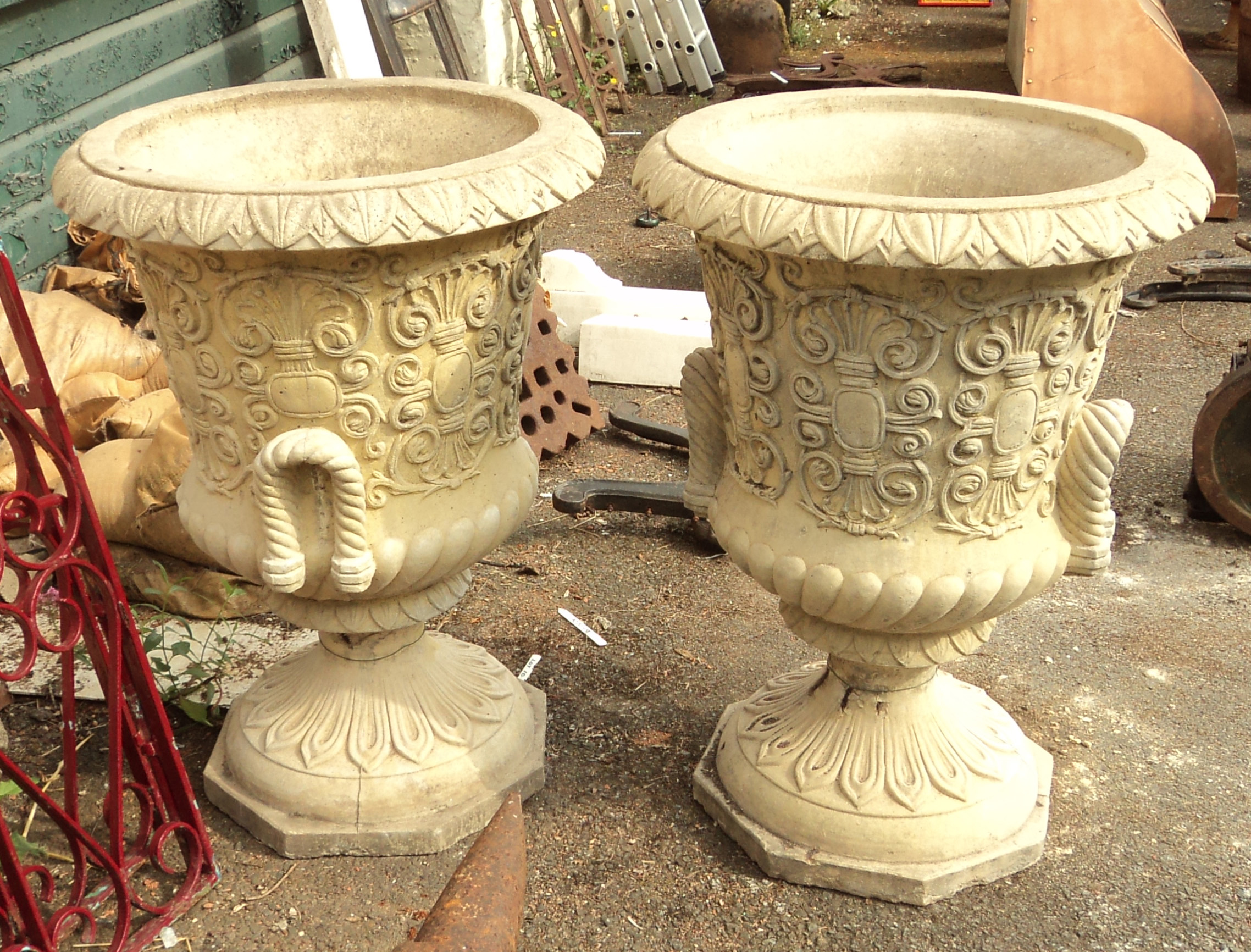 A pair of 27" diameter cast concrete garden urns with rope pattern handles and repeat scroll