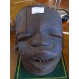 An antique African Lipico carved and blackened wood helmet mask from the Makonde people, with