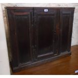 A 30 3/4" antique oak wall hanging cabinet with shelves enclosed by a central panelled door and