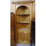 A 3' 4" modern waxed pine corner unit with moulded top, three open shelves and canted sides, over