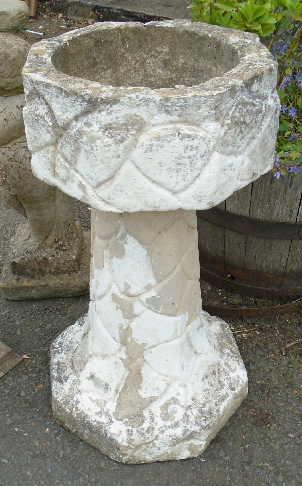 A 2' 6" faceted stone wall pattern pedestal planter