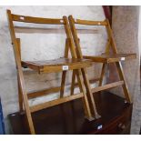 A pair of early 20th Century stained wood framed folding chairs with slatted seat panels and