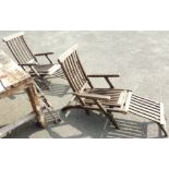 A pair of stained teak steamer chairs with brass fittings