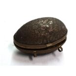 A gilt brass ovoid thimble case with floral decoration and lined interior