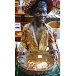 An early 20th Century painted plaster bust of a black boy holding a basket