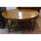 A 3' 6" burr wood and cross banded moulded oval topped coffee table, set on shaped supports with