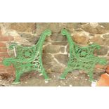 A pair of later green painted cast iron bench ends