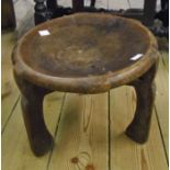 A 13" diameter Ethiopian tribal stool with dished top and triple rustic legs - from a single piece