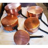 A set of five graduated copper pans