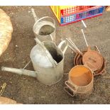 Two galvanised watering cans, three cast iron pans and two two handled pots