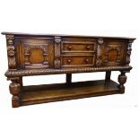 A 6' carved and polished oak potboard dresser base with two central drawers, flanking decorative