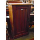 An Edwardian walnut pot cupboard enclosed by a panelled door