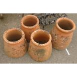 A pair of terracotta chimney pots and two similar