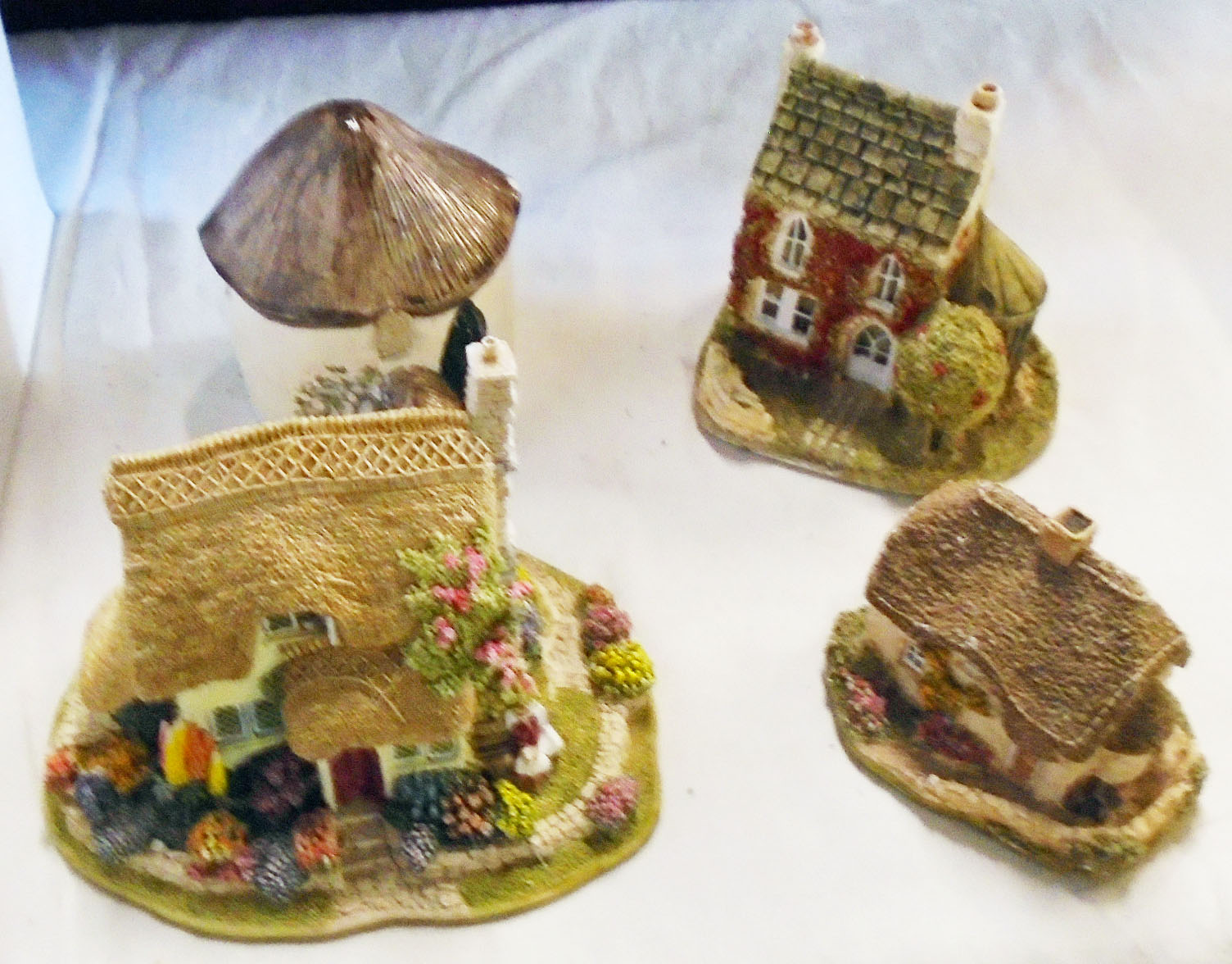 A collection of unboxed Lilliput Lane and other makes of resin model cottages, church, etc.