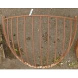 A vintage wrought iron wall mounted corner hay rack