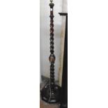An early 20th Century polished oak standard lamp with barley twist column and moulded circular base