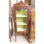 A 20" early 20th Century stained walnut display cabinet with floral boss to raised back and material