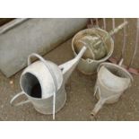 Three galvanized watering cans and a bucket