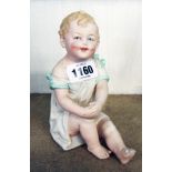 A continental Heubach style piano baby figure - indistinctly marked to base