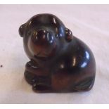 An antique boxwood netsuke carved in the form of a puppy