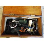 A stained pine tool box containing various door handles, L-brackets, etc.