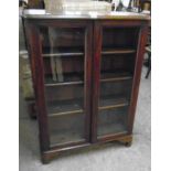 A 33 1/2" Victorian mahogany book cabinet with three adjustable shelves enclosed by a pair of glazed