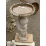 A painted concrete figural birdbath