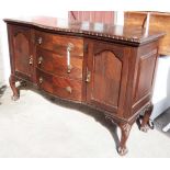 An early 20th Century mahogany break bow front sideboard with flanking cupboards and central