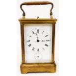 An early 20th Century brass and bevelled glass cased carriage clock with remains of retailer to