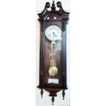 A modern stained wood cased Vienna style regulator wall clock with visible pendulum and spring