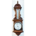 A late Victorian ornate stained oak cased barometer/thermometer with mercury scale and aneroid