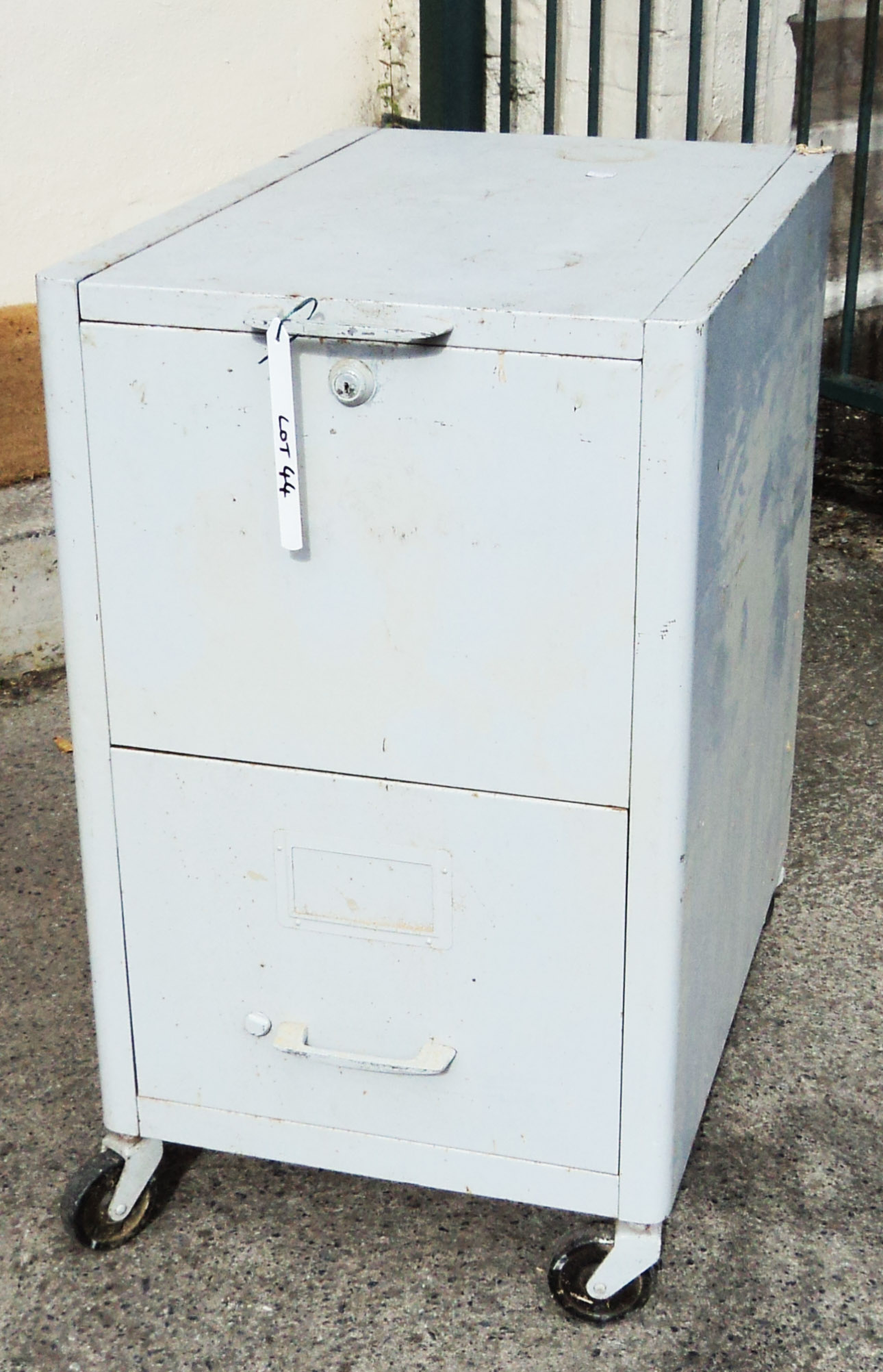 A vintage industrial metal lift top filing cabinet with single drawer under, on large casters -