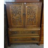 A 4' 7" antique carved mixed wood two part cabinet, with profile portrait beaded roundels to