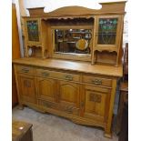 A 5' 11 1/2" early 20th Century Arts and Crafts style golden oak two part sideboard with flanking