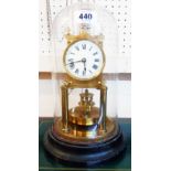 An early 20th Century anniversary clock with wide slab pendulum and white dial under glass dome, set