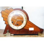 An Art Deco inlaid walnut and metal mounted cased mantel clock with diagonal sunburst design and